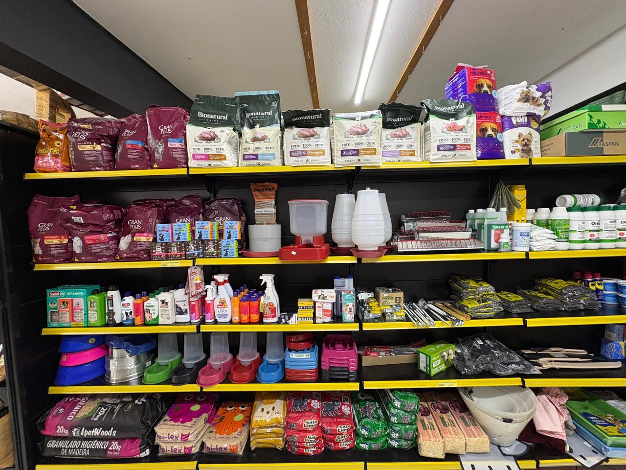 Interior da Agropecuária Rancho dos Pinheiros — prateleiras com produtos para pets, aves e bovinos